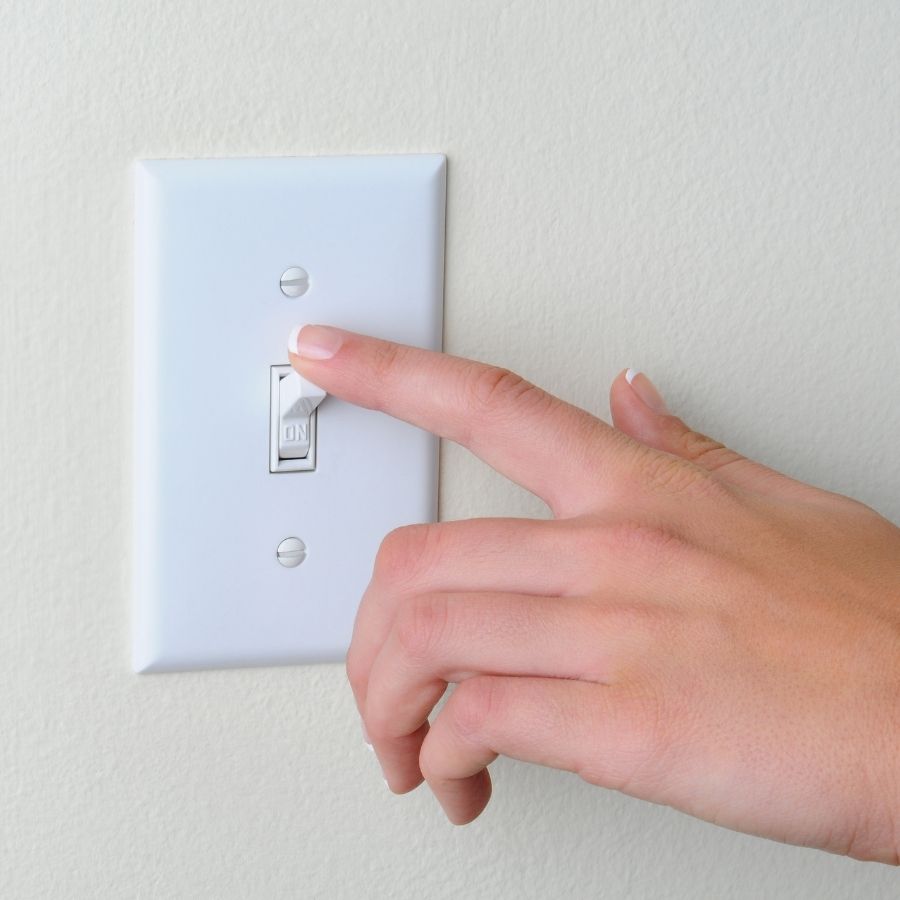 a hand turning off the light